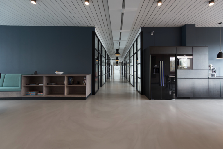 A bright, clean open-plan office in Maine with organized desks, polished floors, and a productive team working — demonstrating the connection between commercial cleaning and workplace productivity